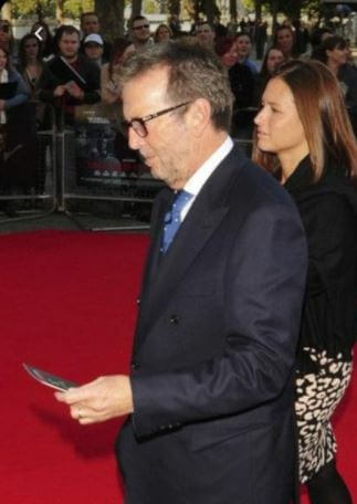 Patricia Molly Clapton son Eric Clapton with Melia McEnery walking on the red carpet.